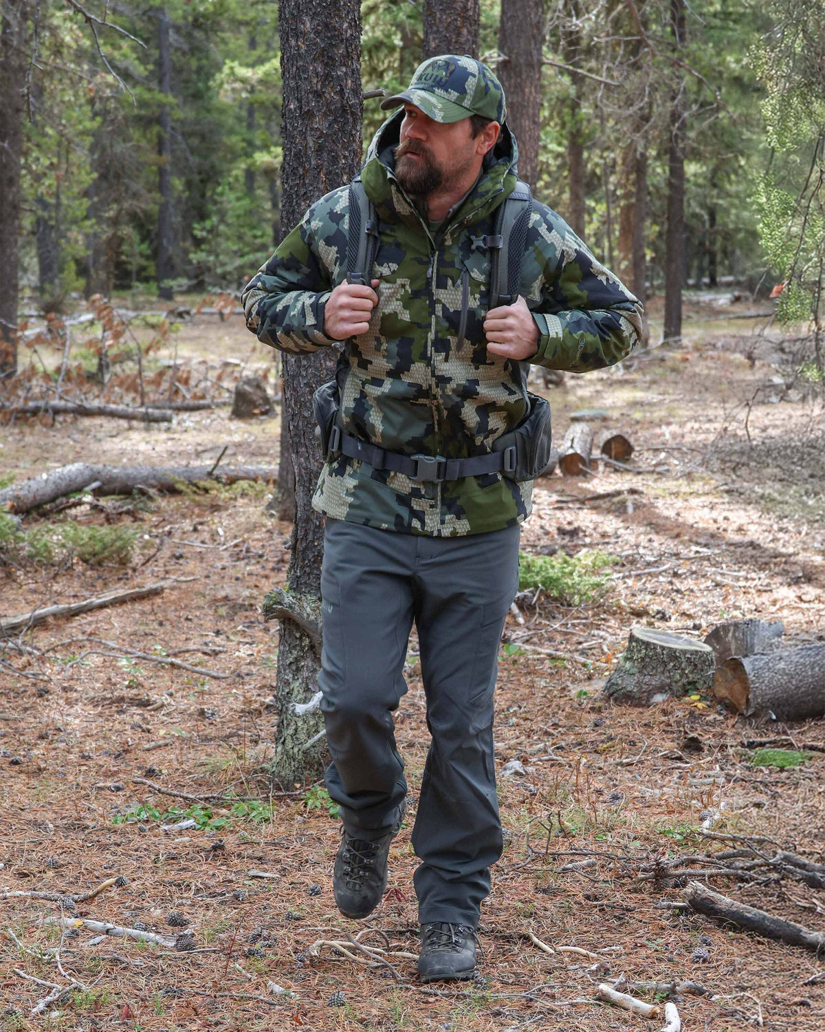 Front of hunter hiking through the forest wearing Attack Pant in Dark Gunmetal Grey
