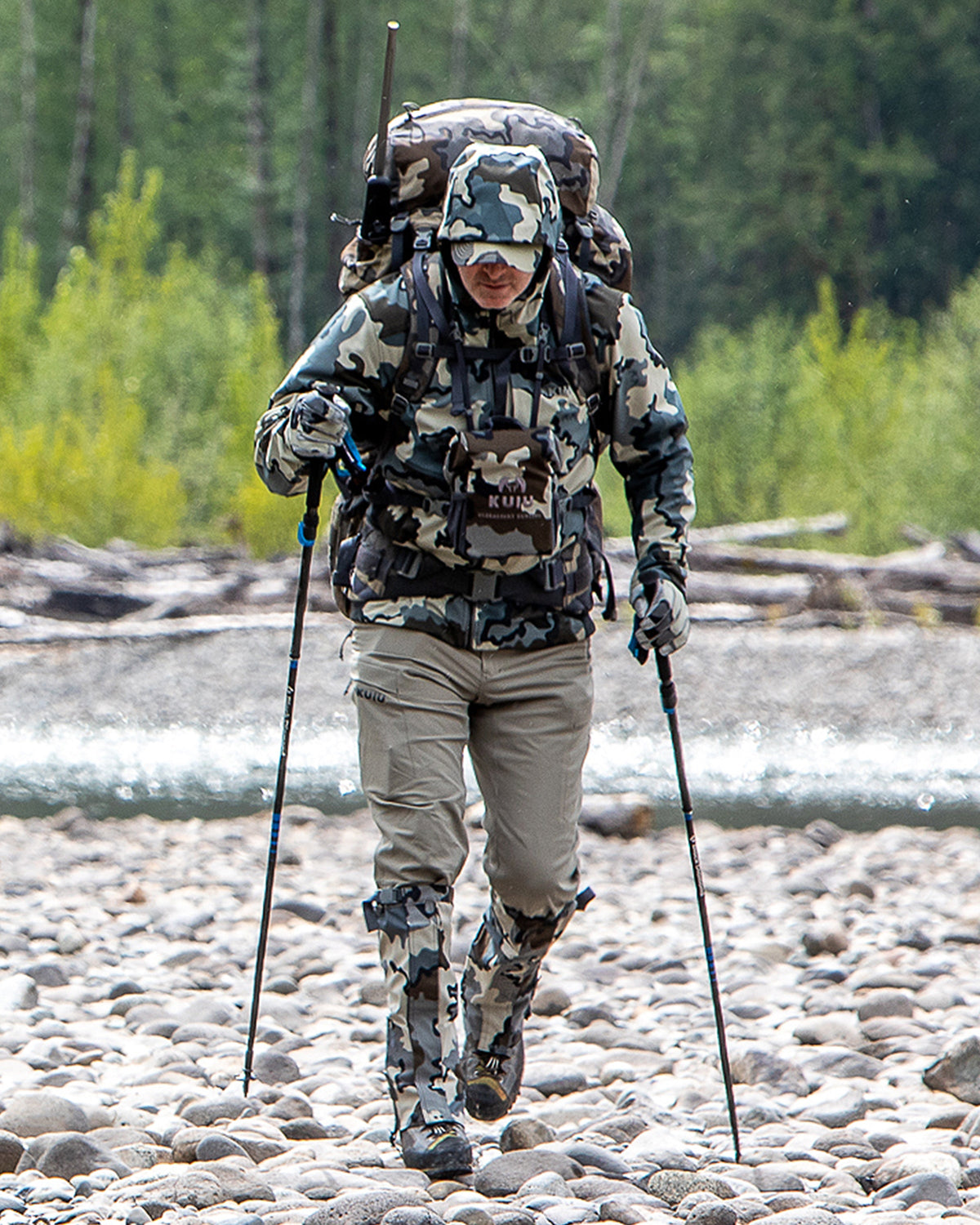 Front of Hunter Hiking Through Rocky, River Bed Wearing Attack Pants in Khaki Color
