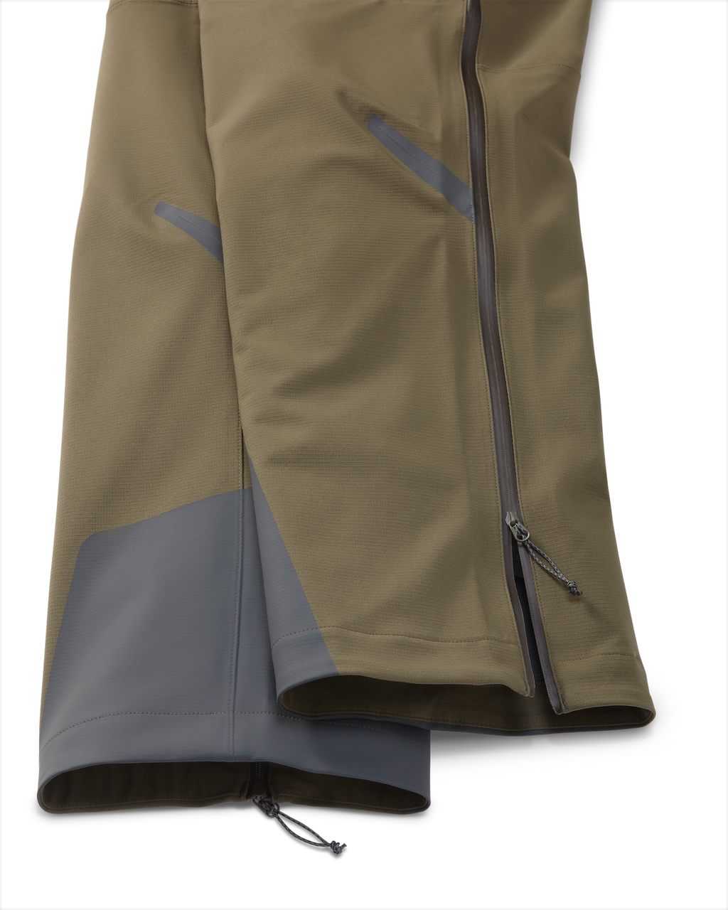 Zoomed in detail the Kutana Storm shell pant in Ash Brown color showcasing side zippers