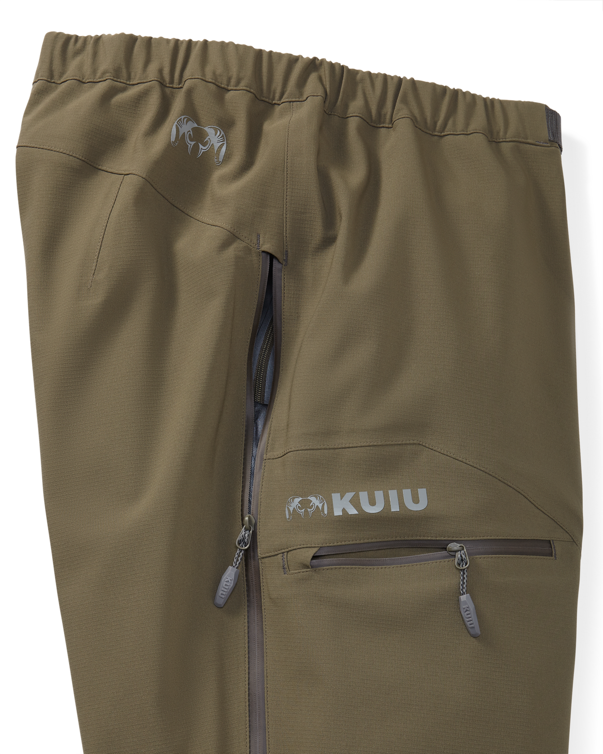 Zoomed in detail the Kutana Storm shell pant in Ash Brown color showcasing side zippers and hand pocket