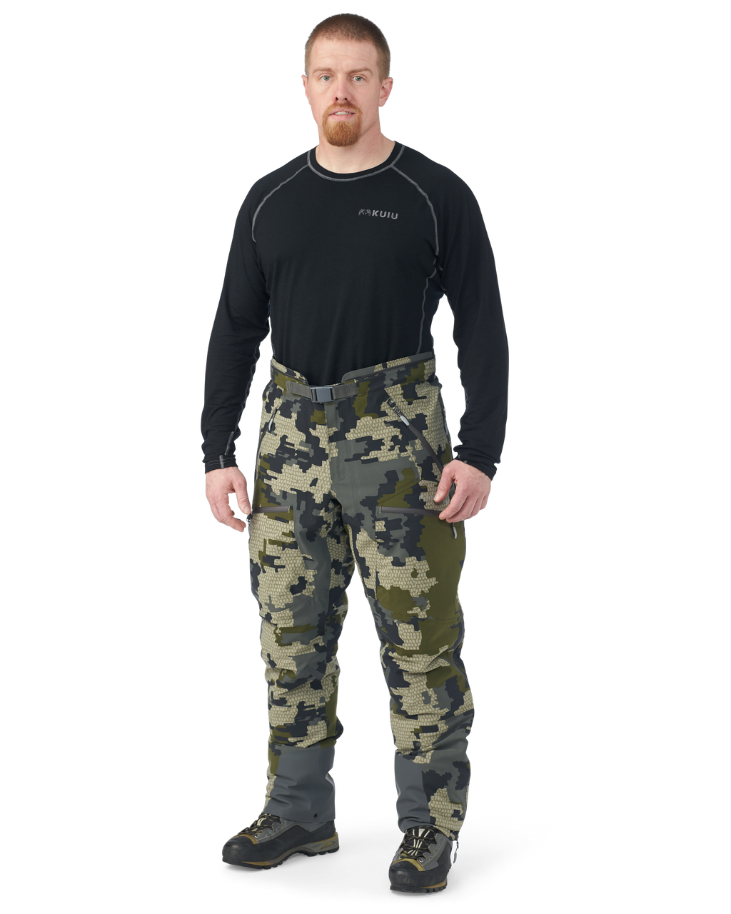 Hunter wearing Kutana Gale Force Pant in Verde Camouflage without suspenders over shoulders