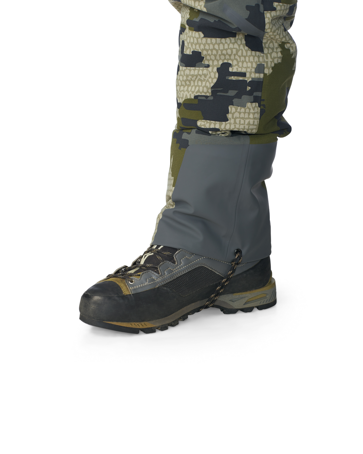 Hunter wearing Kutana Gale Force Pant in Verde Camouflage showcasing bottom ankle grommet