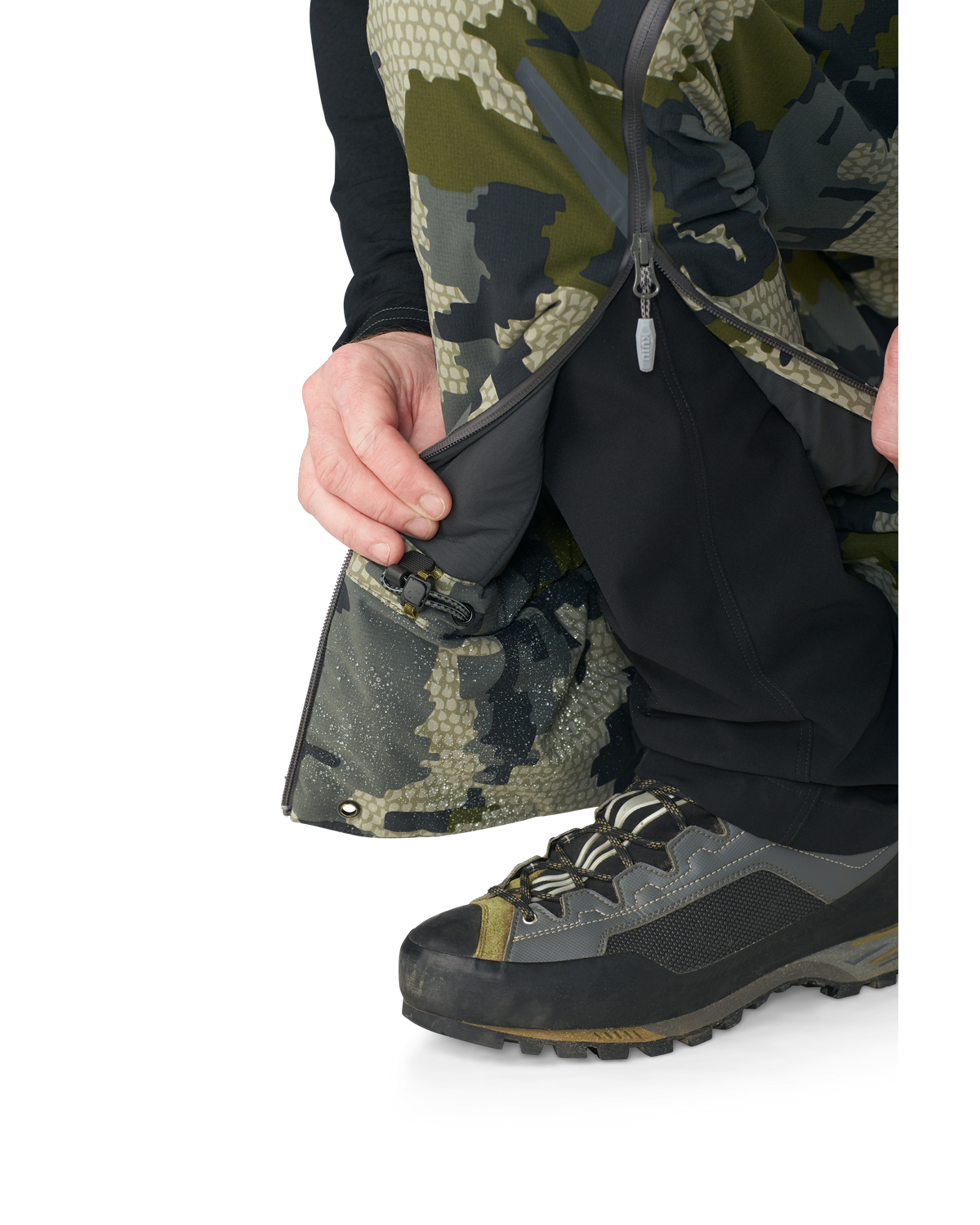 Hunter wearing Kutana Gale Force Pant in Verde Camouflage showcasing inner ankle fabric