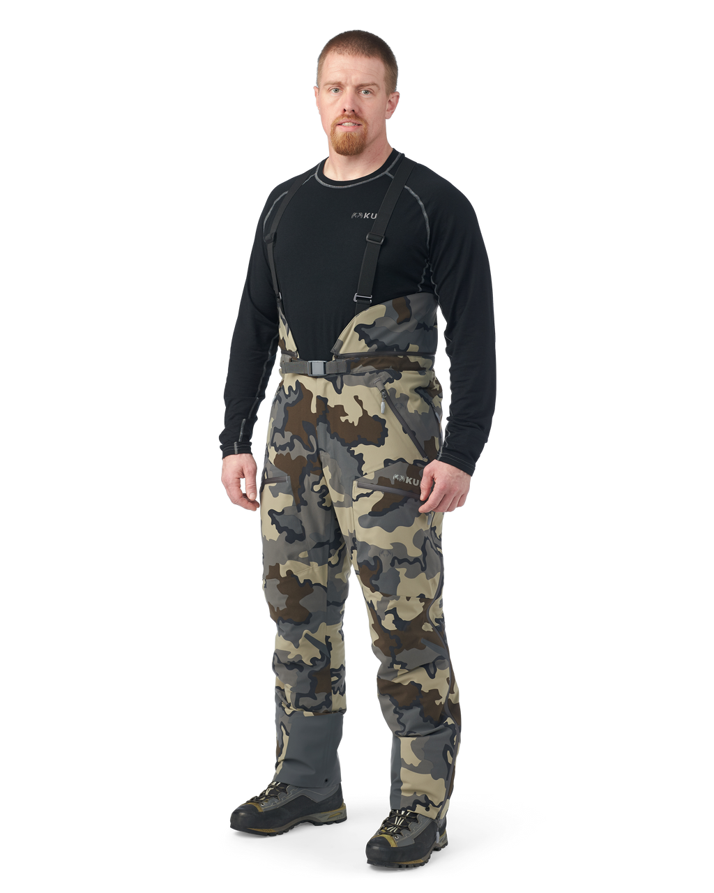 Hunter wearing Kutana Gale Force Pant in Vias Camouflage with suspenders over shoulders