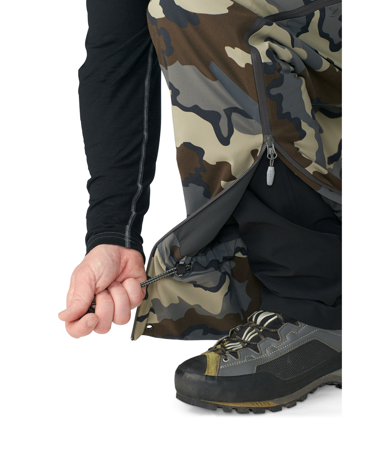 Hunter wearing Kutana Gale Force Pant in Vias Camouflage showcasing inner ankle cinch cord