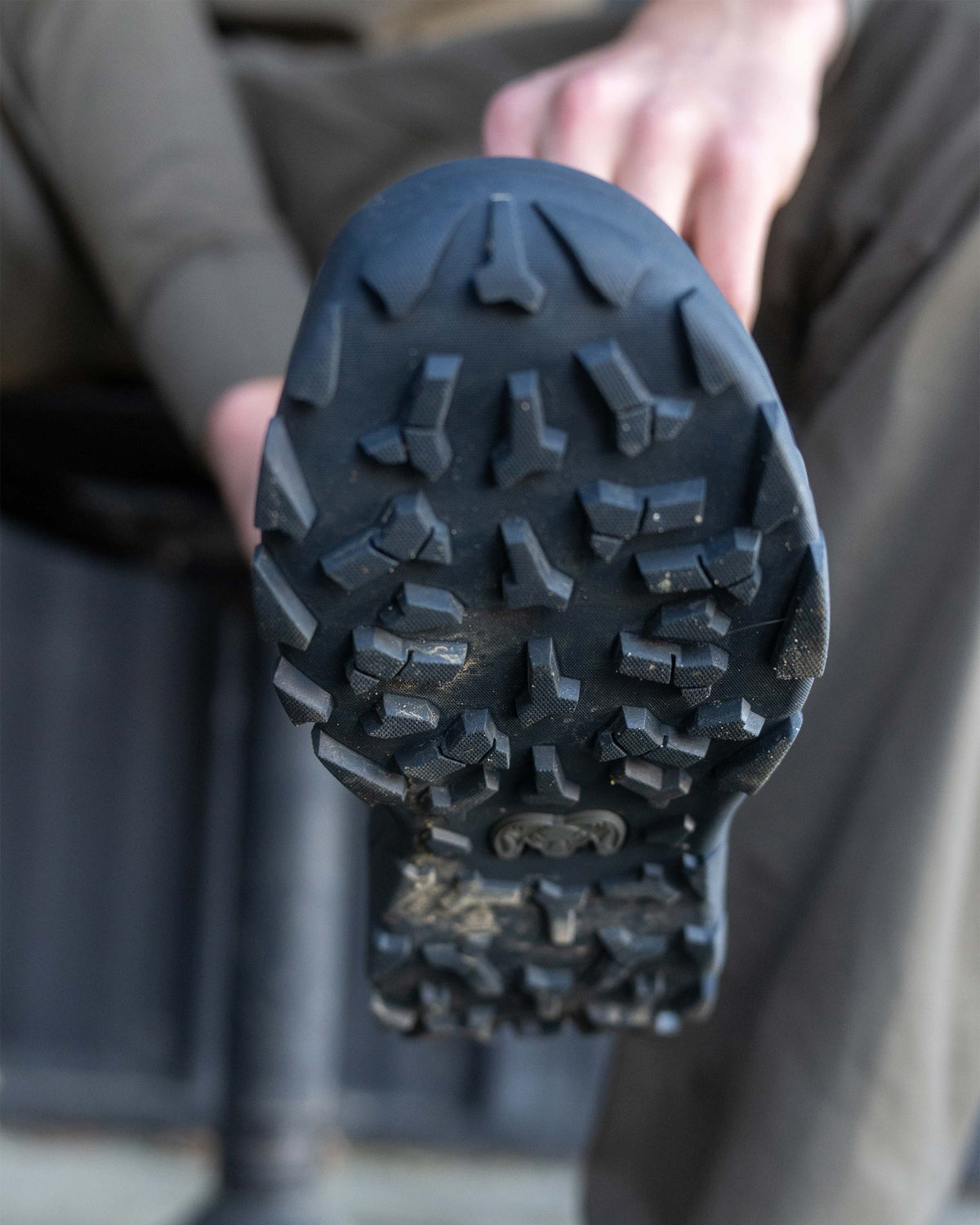 Hunter displaying the bottom outsole grip of the KUIU Ankle Mud Boot in Valo Camouflage