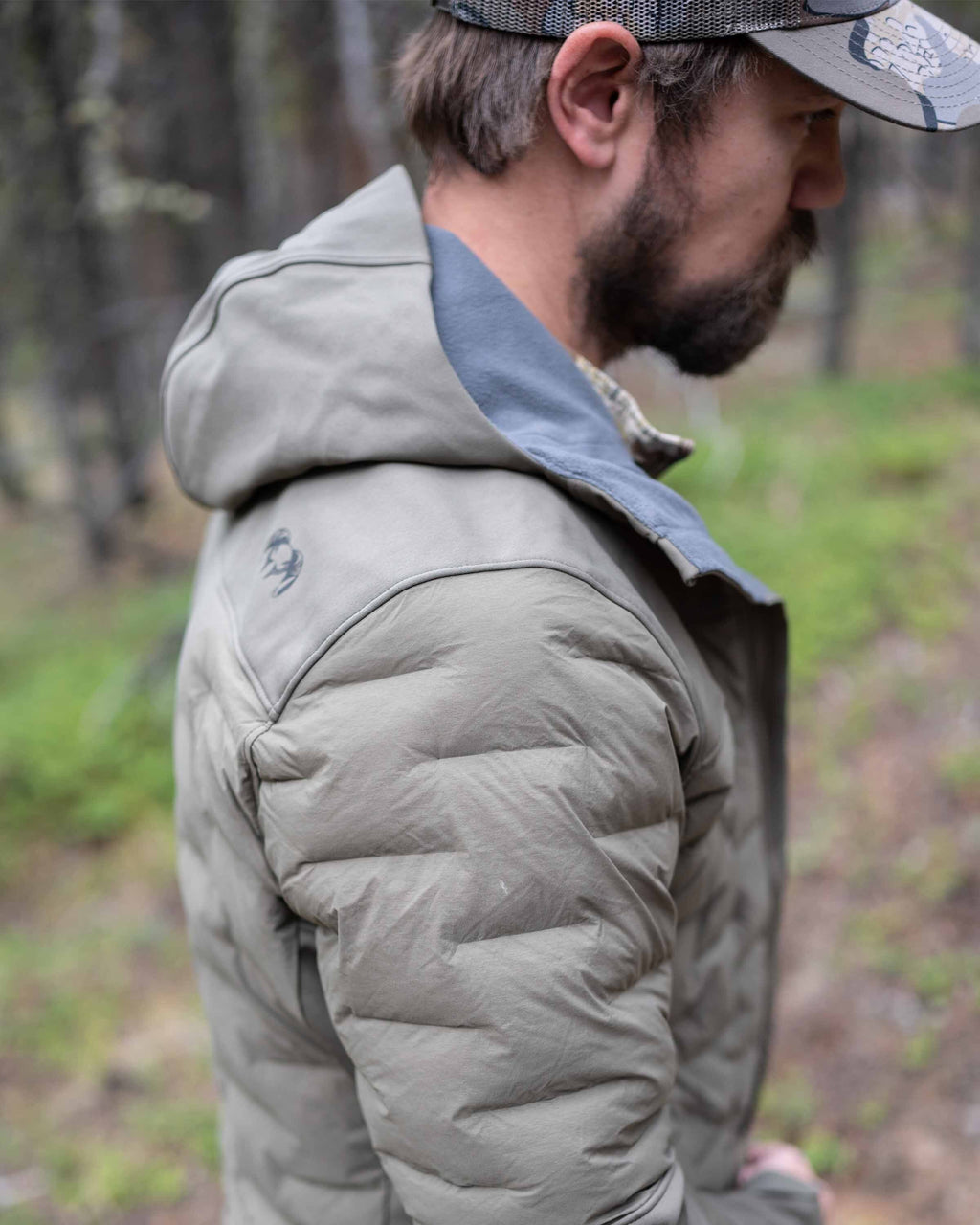 Hunter with focus on shoulder area wearing Axis Thermal Hooded Jacket in Ash Brown