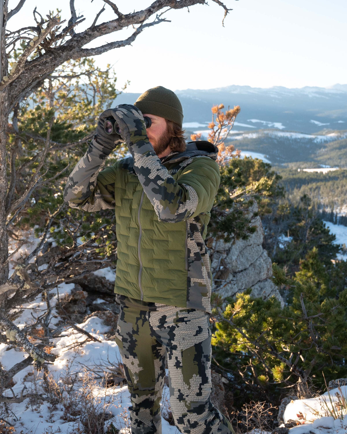 Front, Angled View of Hunter Glassing Game Wearing Axis Thermal Hybrid Hooded Jacket in Verde Camouflage