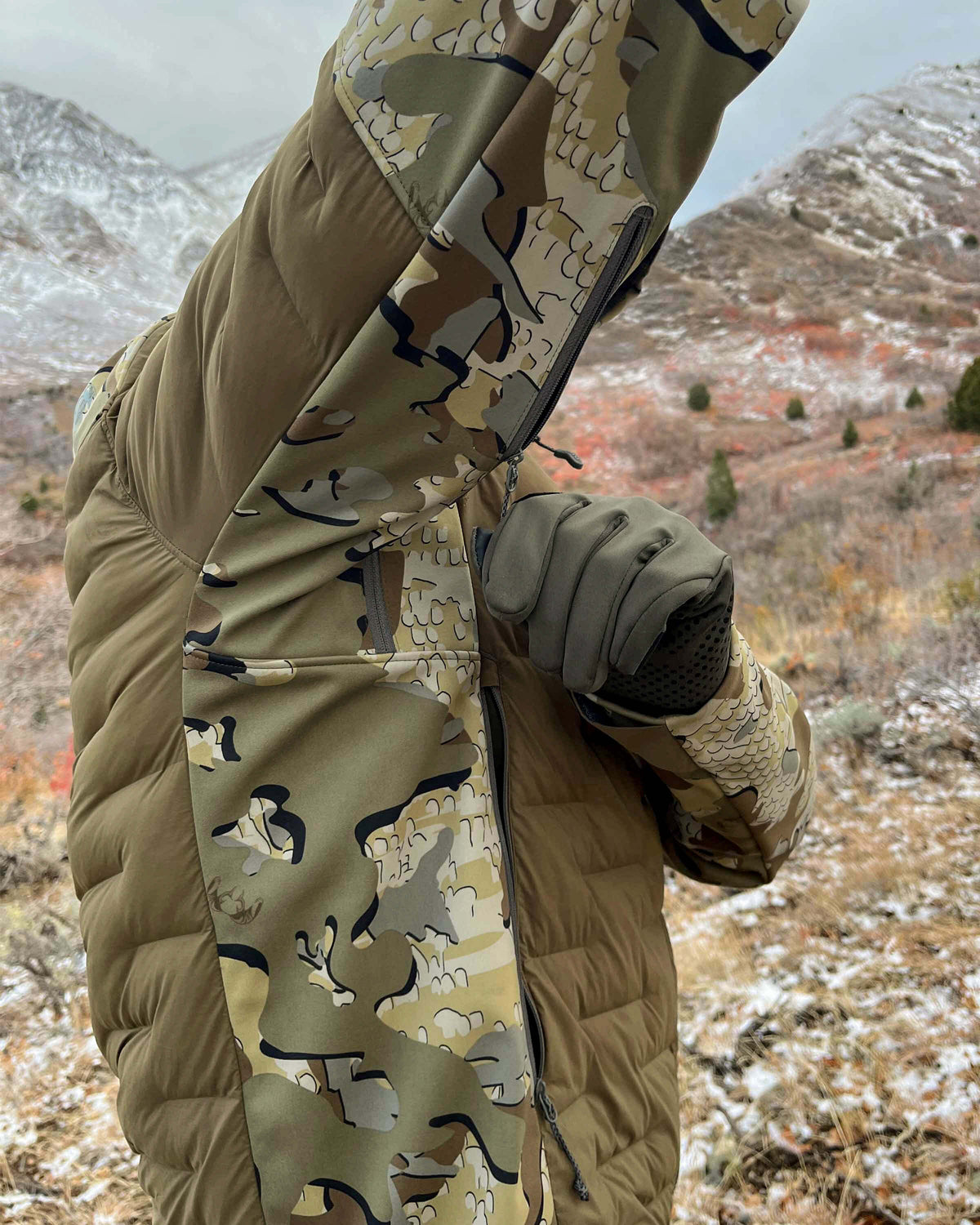 Side of Hunter Wearing Axis Thermal Hybrid Hooded Jacket in Valo Camouflage Highlighting YKK Zippered Pit Vents