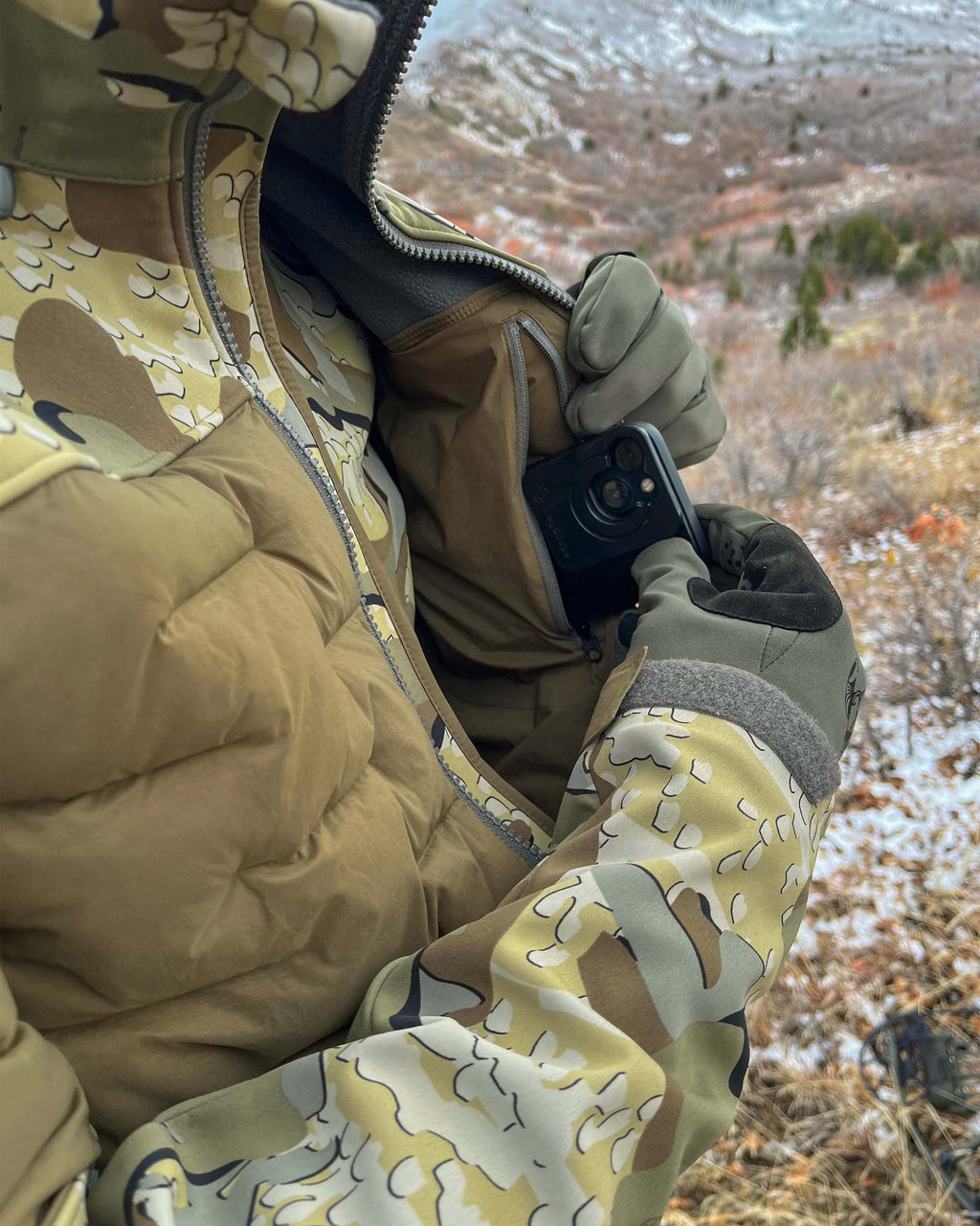 Front, Angled View of Hunter Wearing Axis Thermal Hybrid Hooded Jacket in Valo Camouflage Highlighting Internal, Zippered Chest Pocket