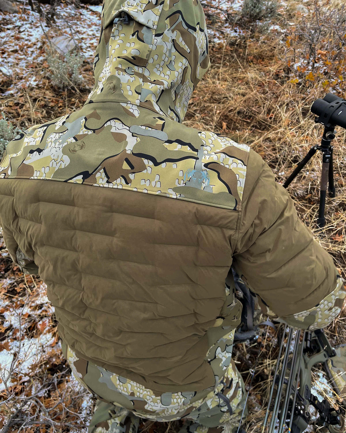 Rear, Angled View of Hunter Wearing Axis Thermal Hybrid Hooded Jacket in Valo Camouflage Highlighting Waterproof Paneling in Hood, Shoulders and Neck