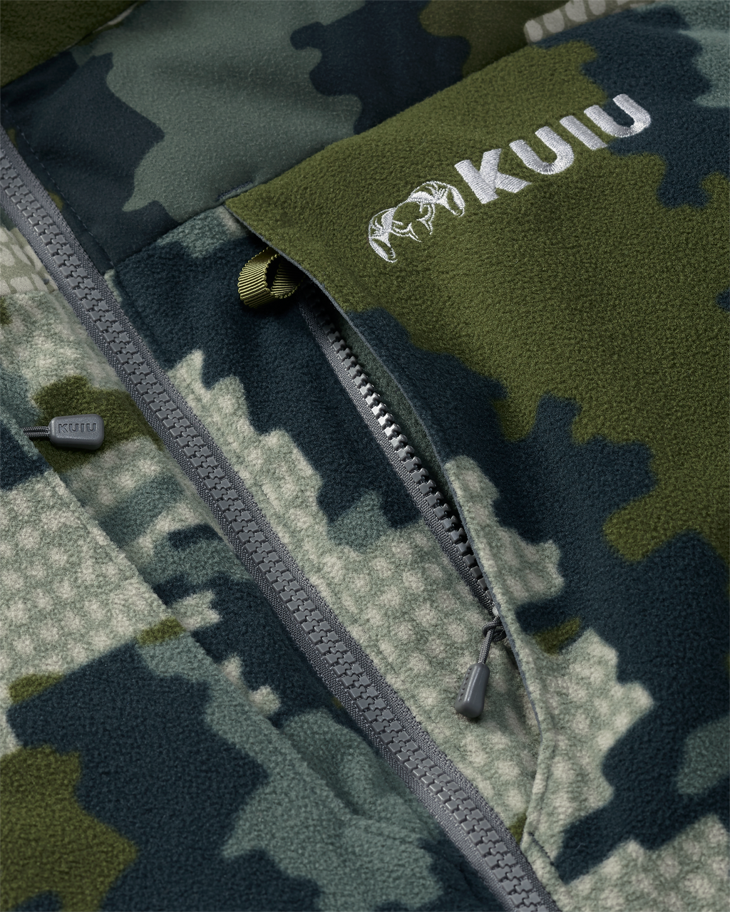 Close-up of vertical zippered chest pocket with inside accessory loop attachment on the Super Down Haven Hooded Jacket in Verde Camouflage