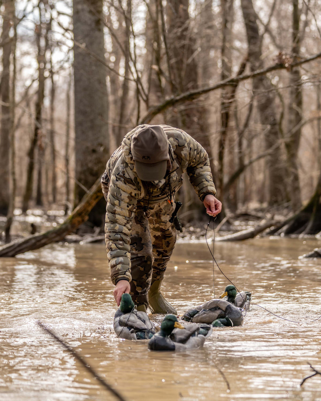 Hunter Wearing Flyway Insulated Hooded Jacket in Valo Camouflage Collecting Mallard Decoys in Flooded Timber