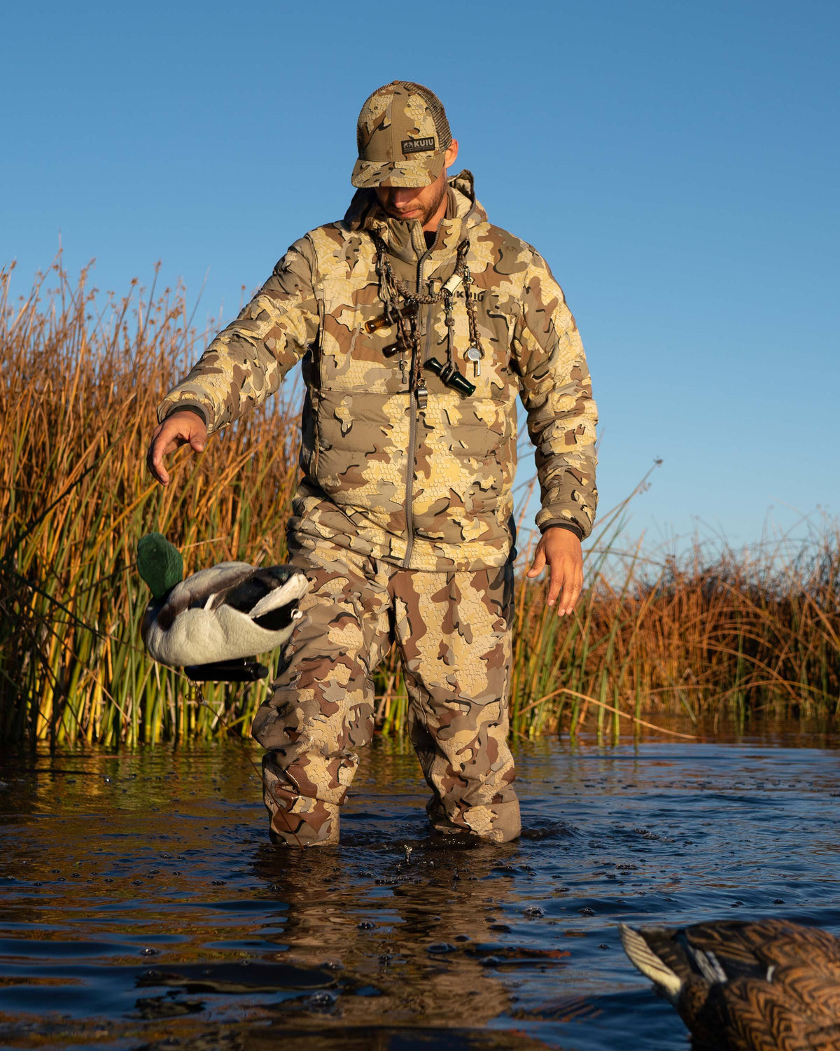 Hunter Wearing Flyway Insulated Hooded Jacket in Valo Camouflage tossing Mallard Decoy Showing Front of Jacket