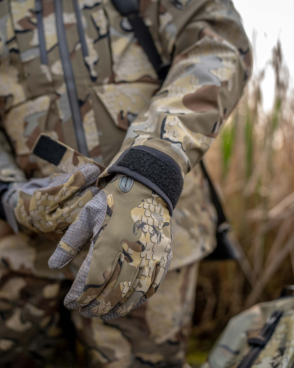 Detail waterfowl hunter tightening the neoprene cuff on the HD Flex Storm Shell Jacket in Valo Camouflage