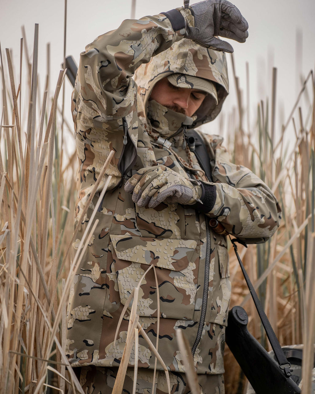 Detail hunter in reeds wearing HD Flex Storm Shell Jacket in Valo Camouflage using pit zip ventilation