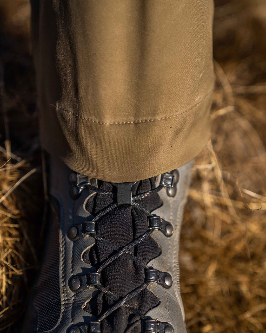Detail of boot hook hooked to lace on hunter wearing PRO Brush Pant in Valo Camouflage