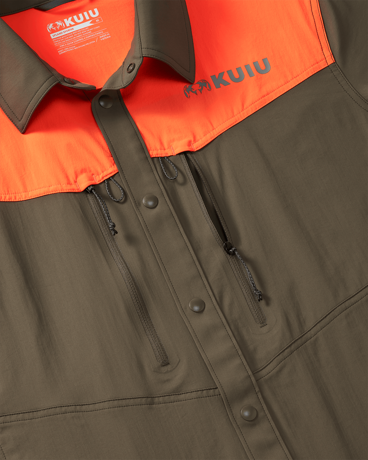 Details highlighting front chest zippered pockets, snap button front placket and accessory loop attachment points on the KUIU Upland Sport Shirt in Major Brown/Blaze Orange