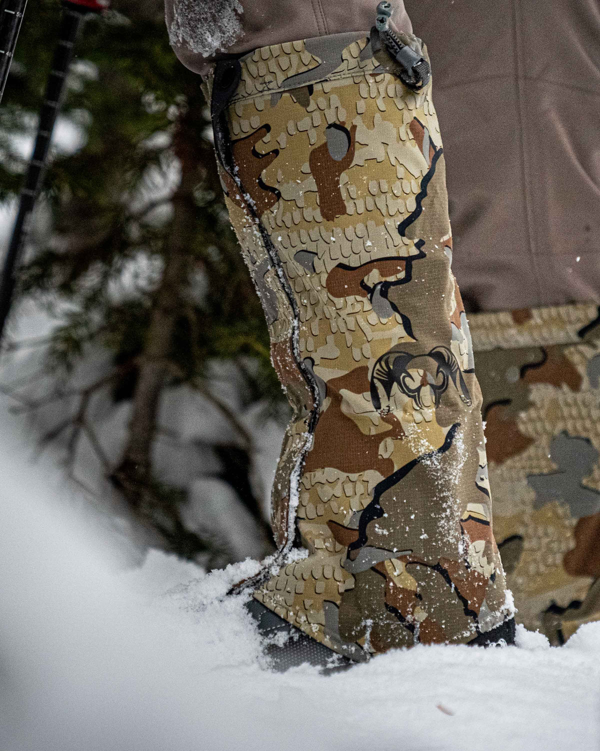 Side of Hunter Standing in Snow Wearing Kutana Storm Gaiters in Valo Camouflage