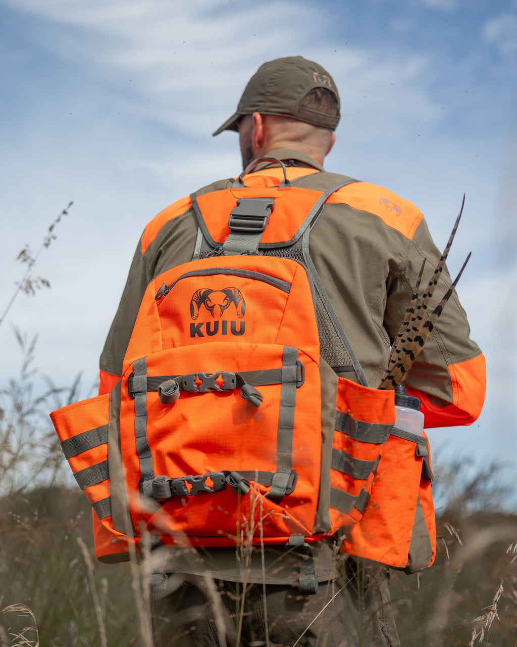 Back view of Hunter wearing Upland Field Vest in Blaze Orange