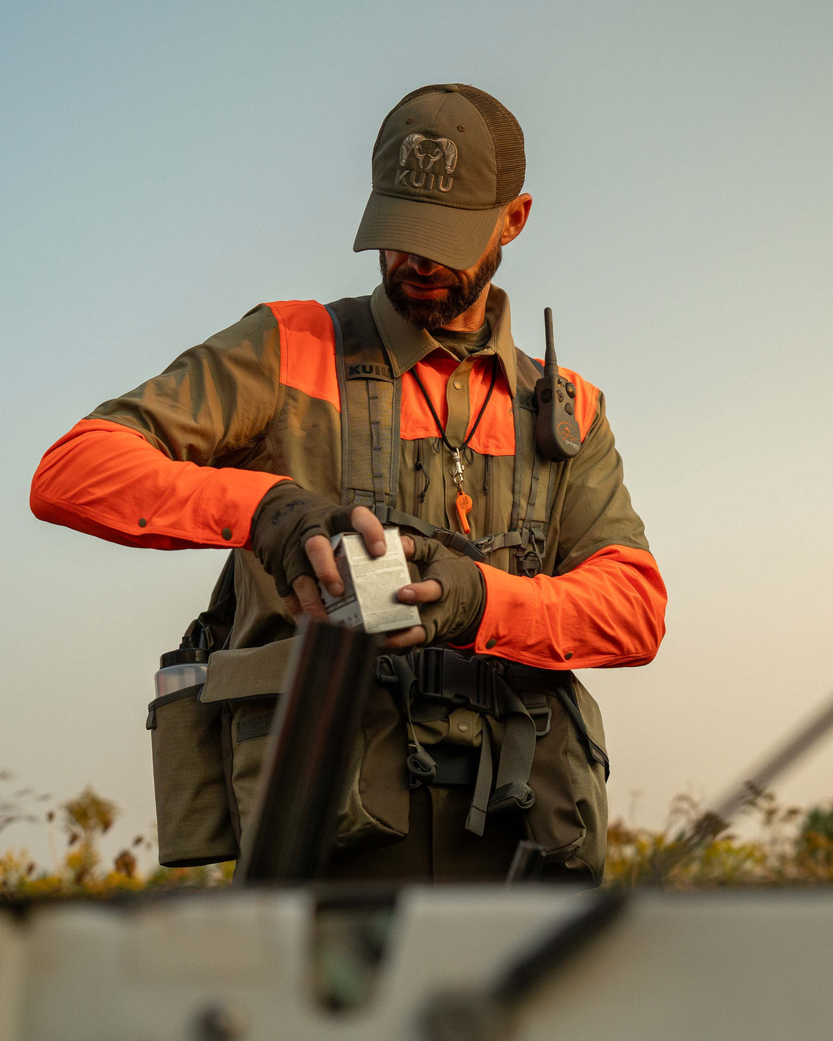 Hunter wearing Upland Field Vest, putting a box in his front pouch pocket