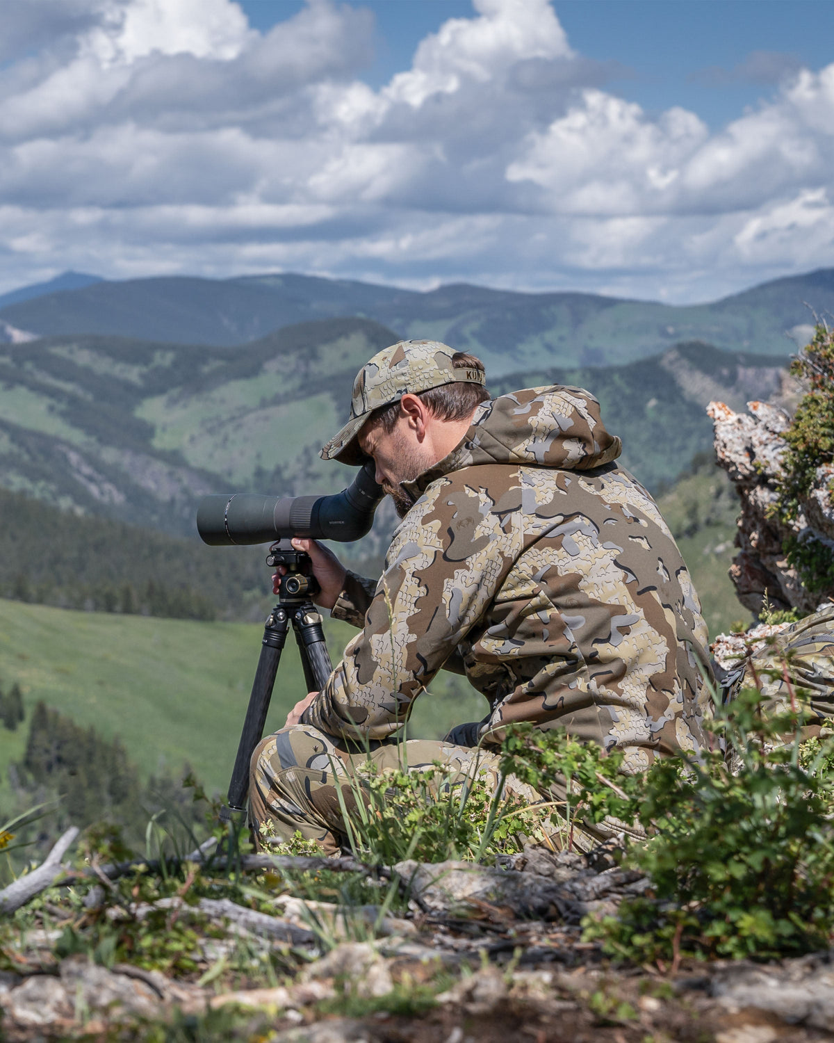 Hunter seated, glassing from a spotter wearing StrongFleece 275 Full Zip Hoodie in Valo Camouflage