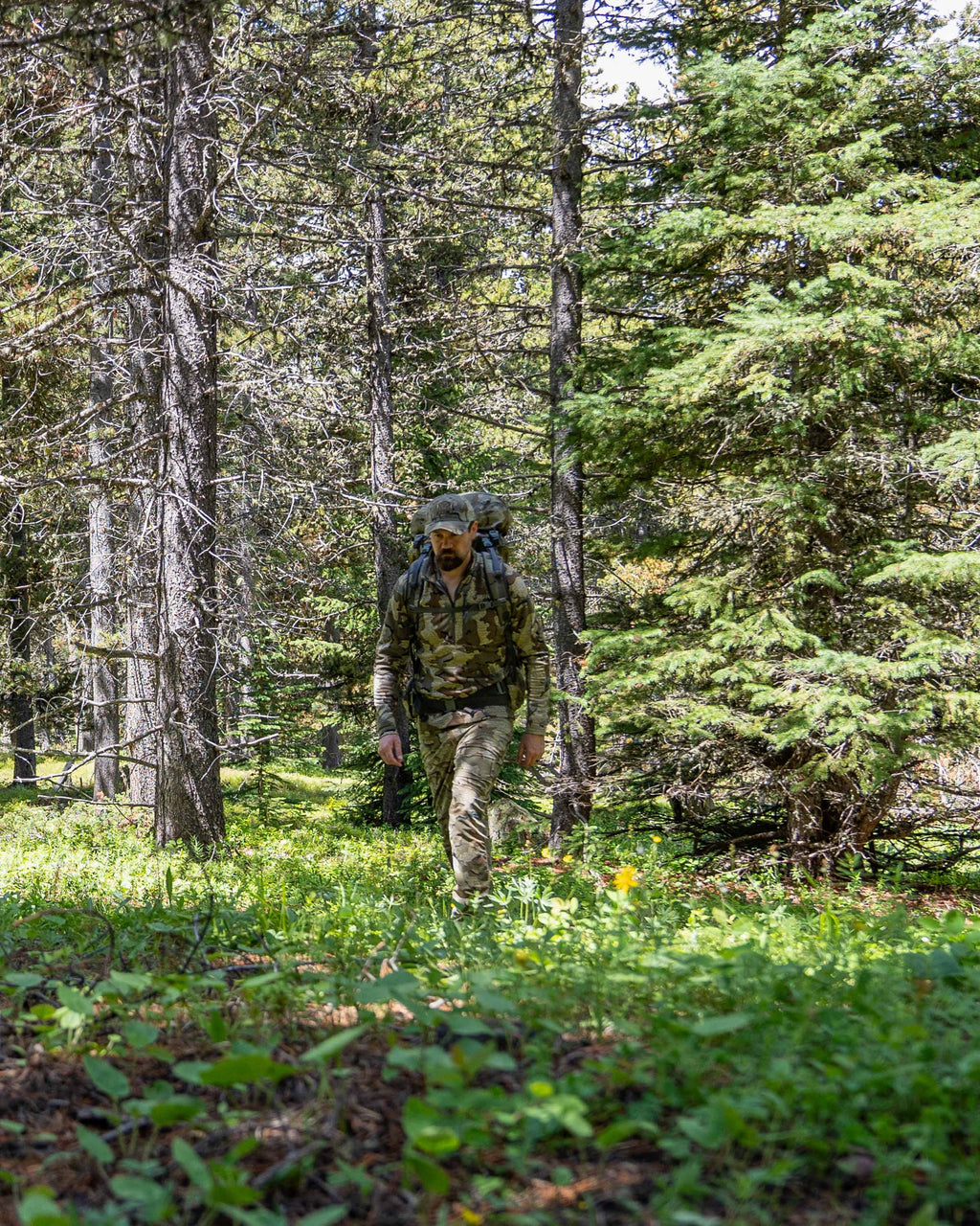 Hunter walking in forested area wearing StrongFleece 1920 Zip-T in Valo Camouflage