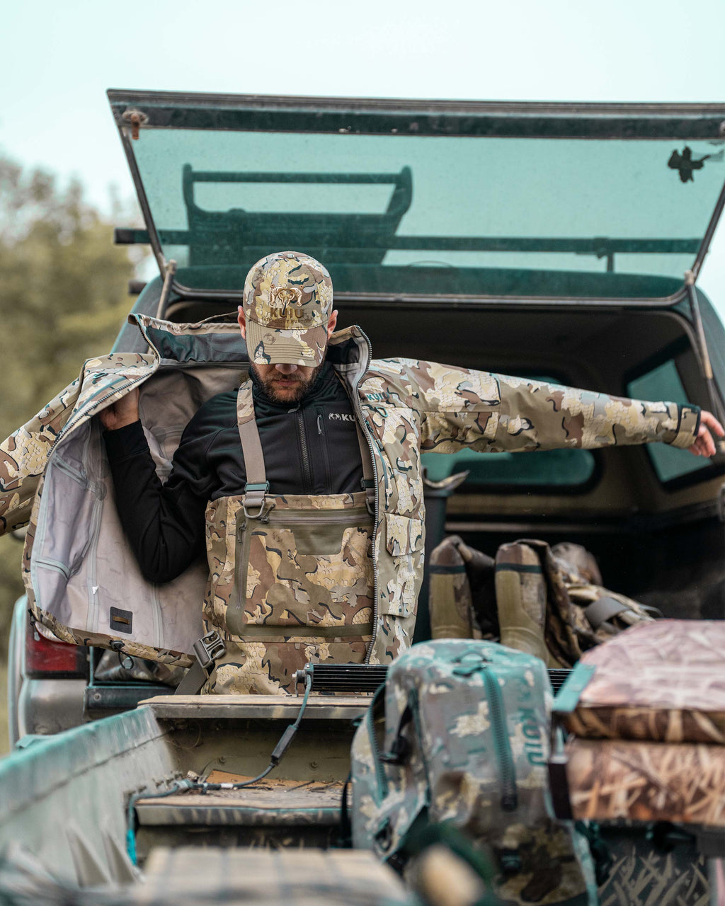 Hunter Standing in Front of Truck Bed Putting Jacket over StrongFleece 290 WF Full Zip in Black