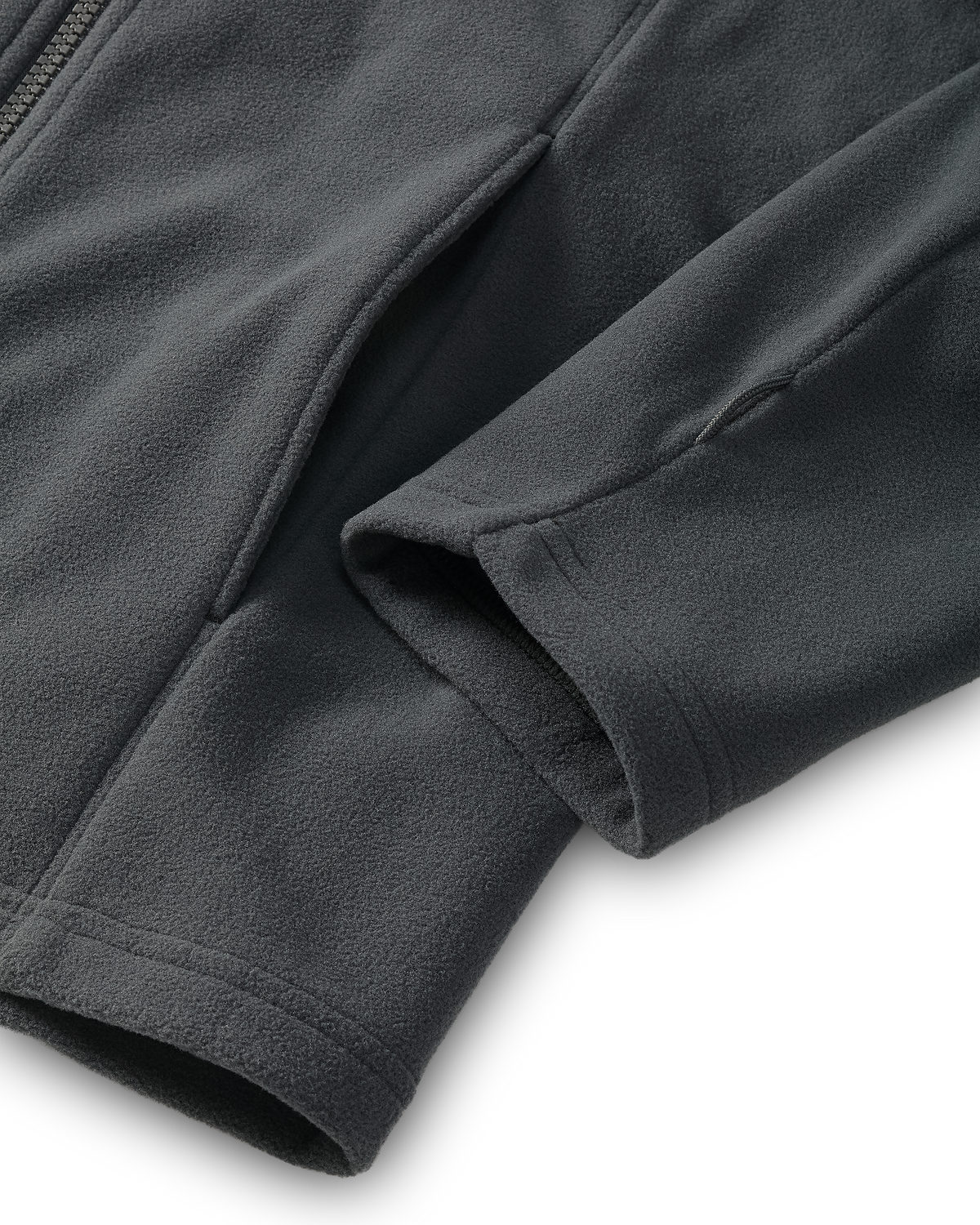 Close-up of the hand pocket and sewn utility loop on the bottom sleeve of a Youth Versa Fleece Full Zip in Gunmetal Grey.