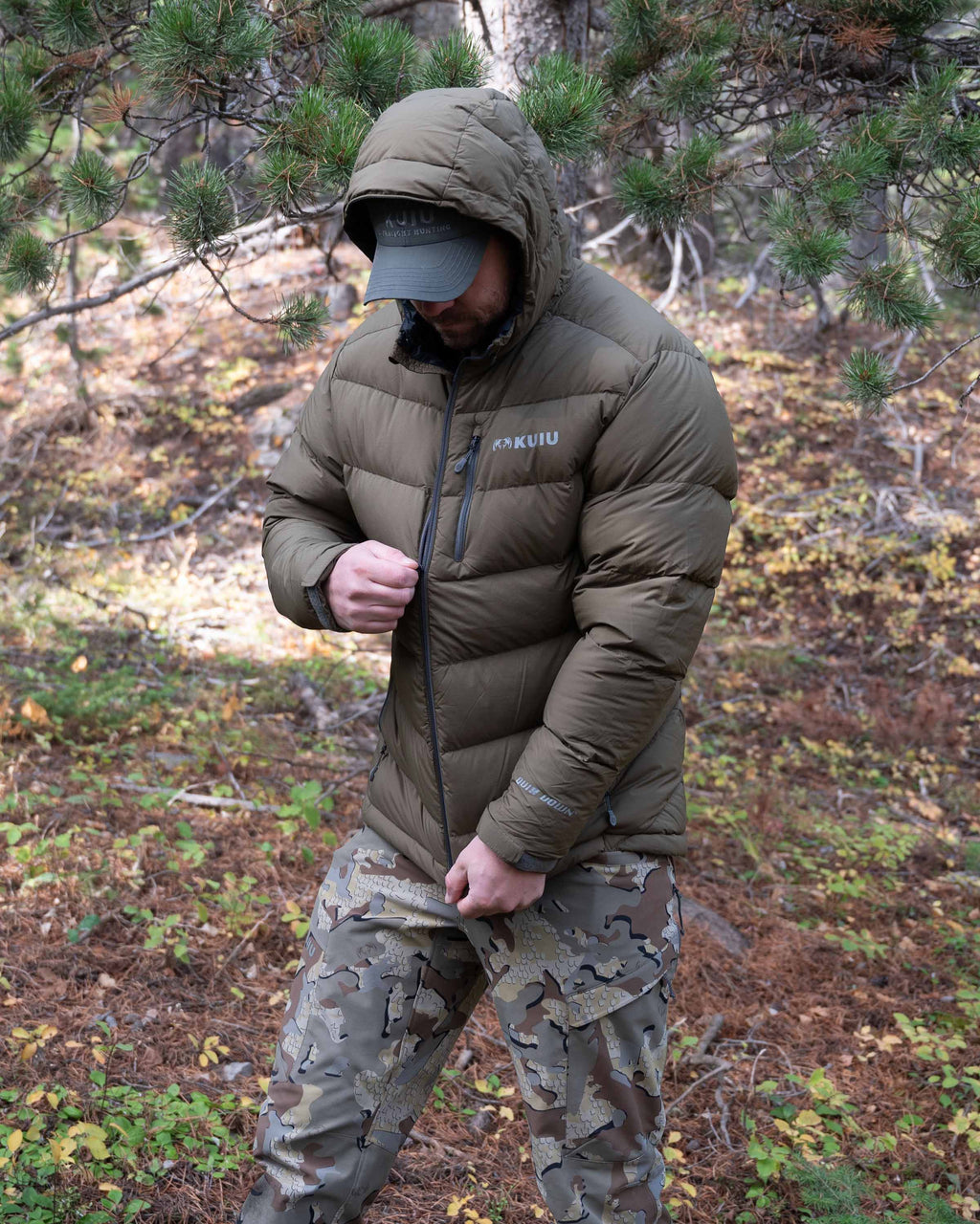 Hunter Zipping up the Super Down PRO Hooded Jacket in Bourbon