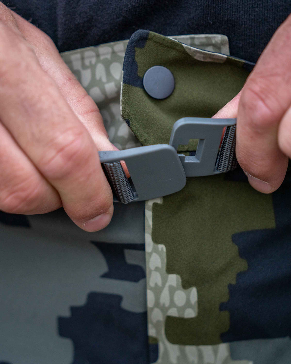 Detail hunter using the adjustable waist with built-in belt on Chugach TR Rain Pant in Verde Camouflage