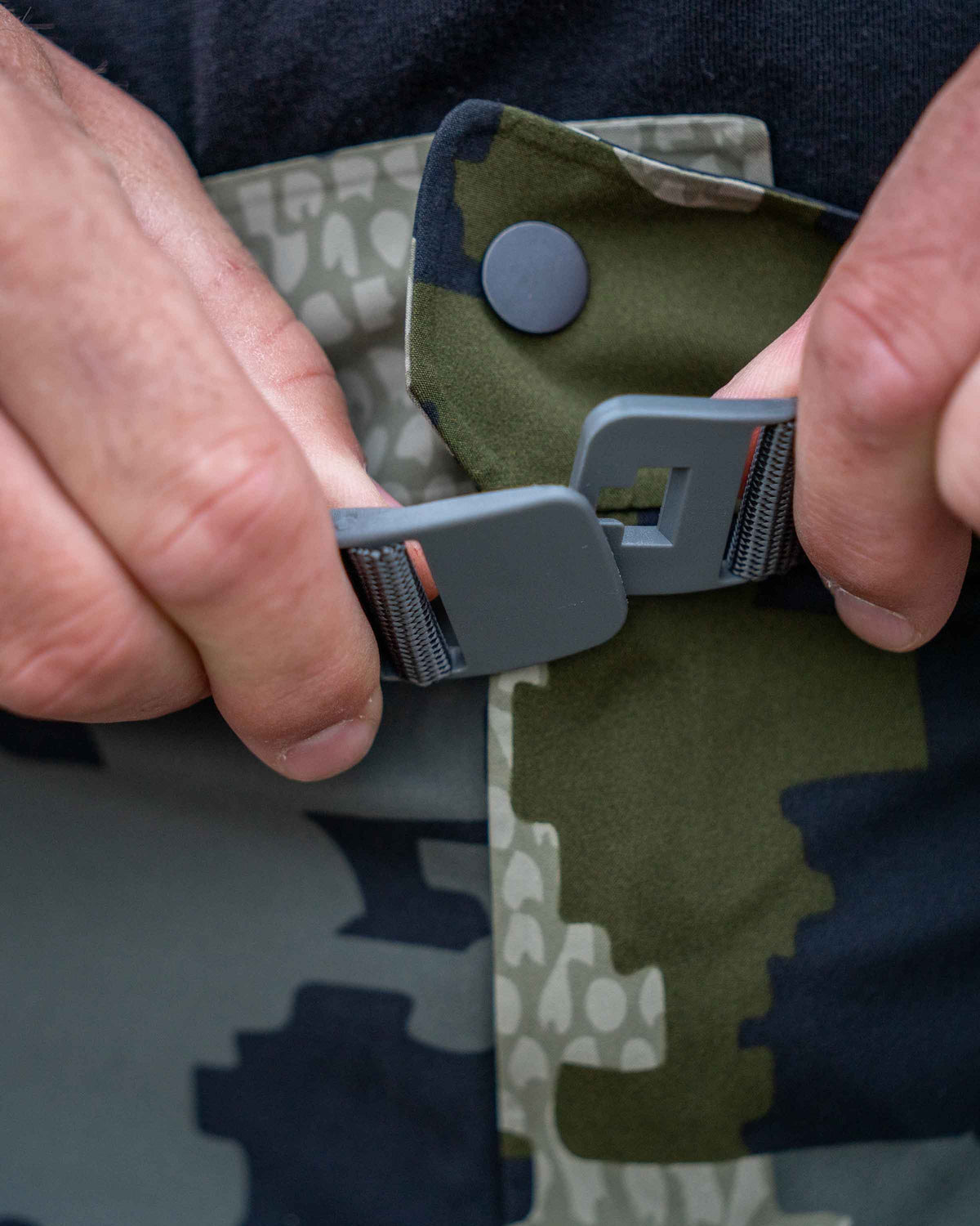 Detail hunter using the adjustable waist with built-in belt on Chugach TR Rain Pant in Verde Camouflage