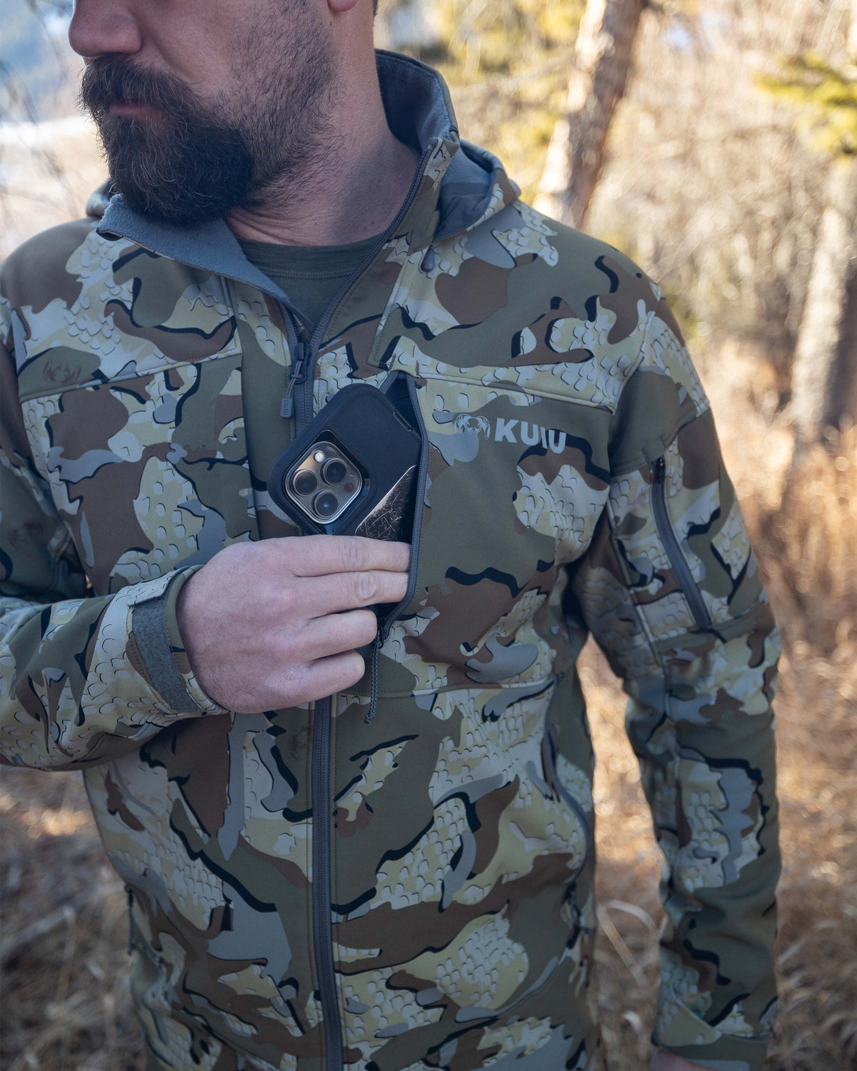 Hunter Removing Phone From YKK Zippered Chest Pocket on Guide PRO Hooded Jacket in Valo Camouflage