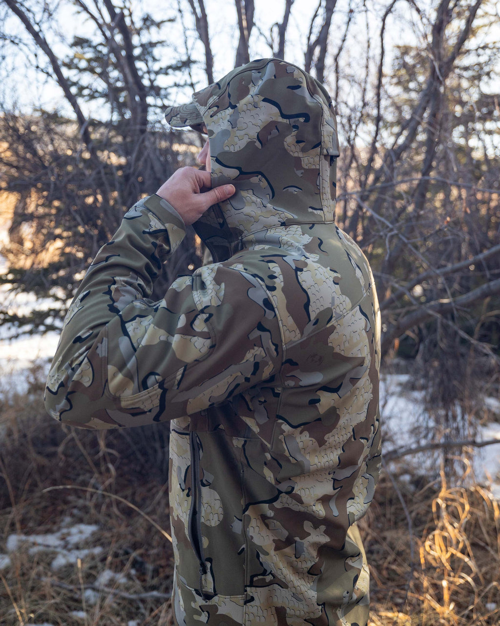 Hunter Wearing Guide PRO Hooded Jacket in Valo Camouflage Holding 2-way Adjustable Storm Hood