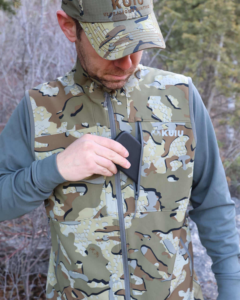 Hunter Removing Phone from Zippered YKK Chest Pocket Wearing Guide PRO Vest in Valo Camouflage