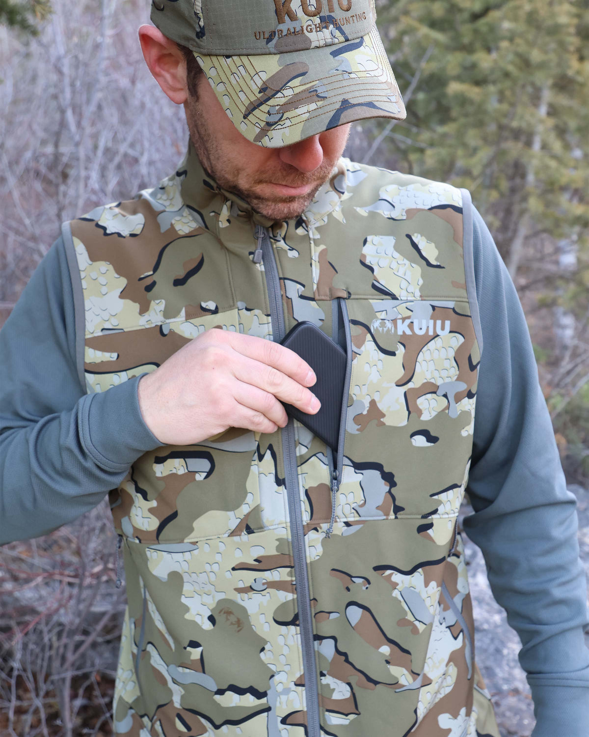 Hunter Removing Phone from Zippered YKK Chest Pocket Wearing Guide PRO Vest in Valo Camouflage