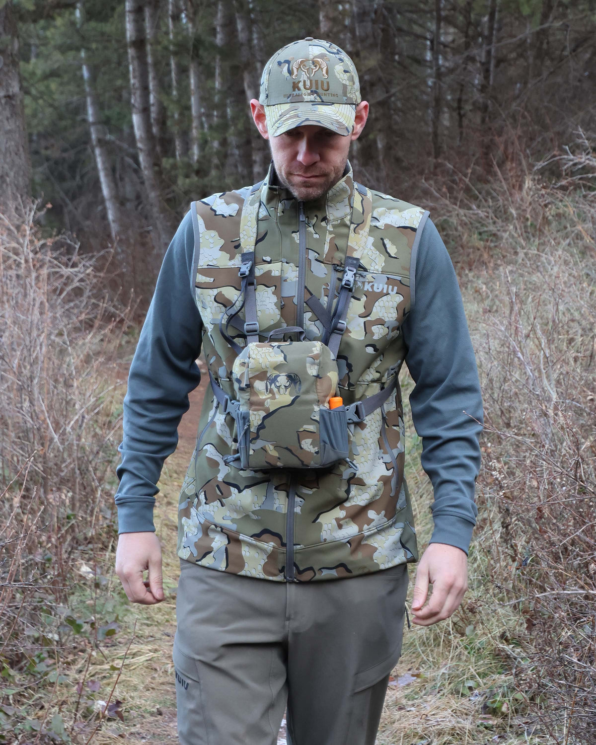 Frontal view of Guide PRO Vest in Valo Camouflage with hunter walking forward while wearing PRO Bino Harness in Valo Camouflage