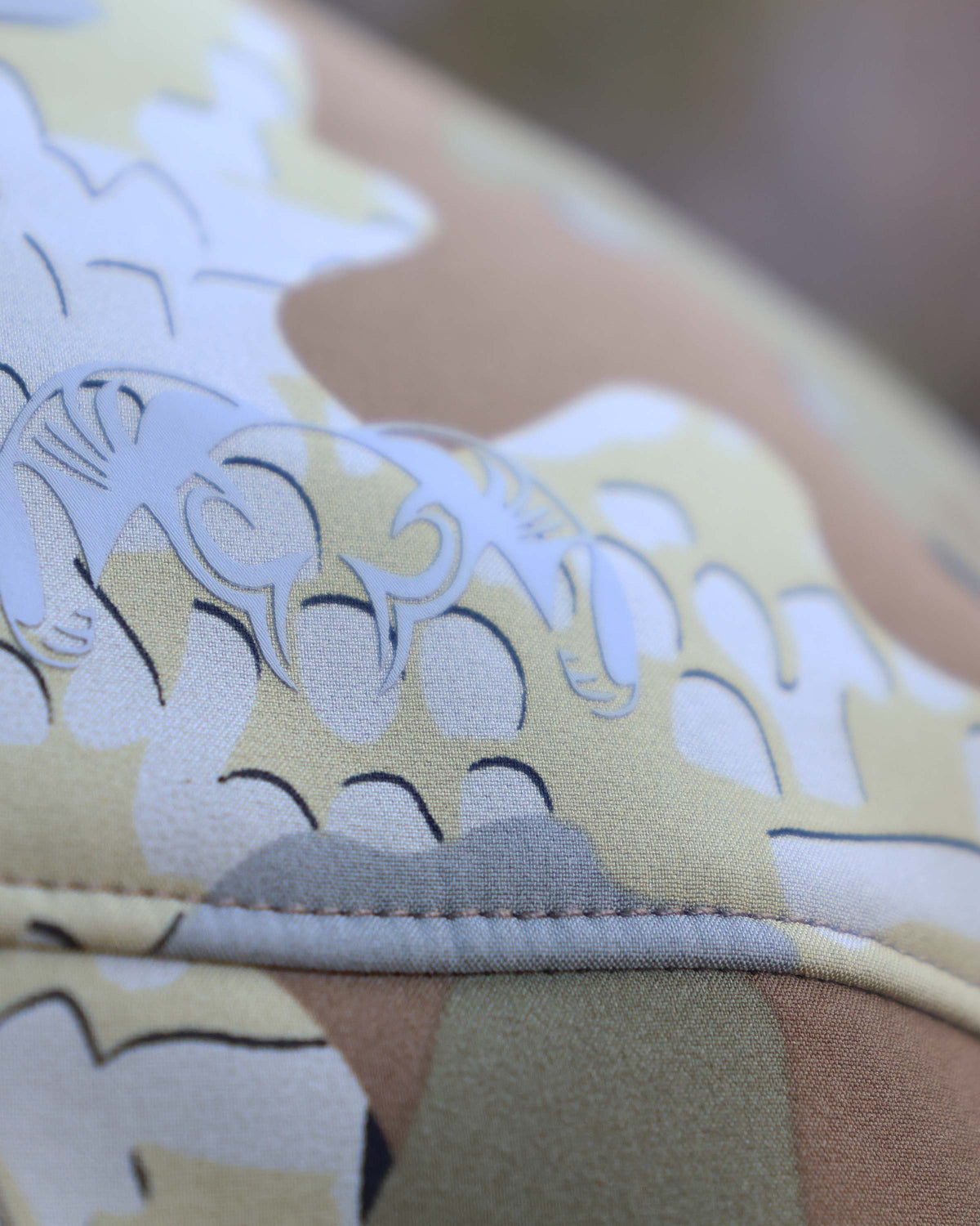 Close up view of stitching on Guide PRO Vest in Valo Camouflage also displaying KUIU Ram Skull Logo