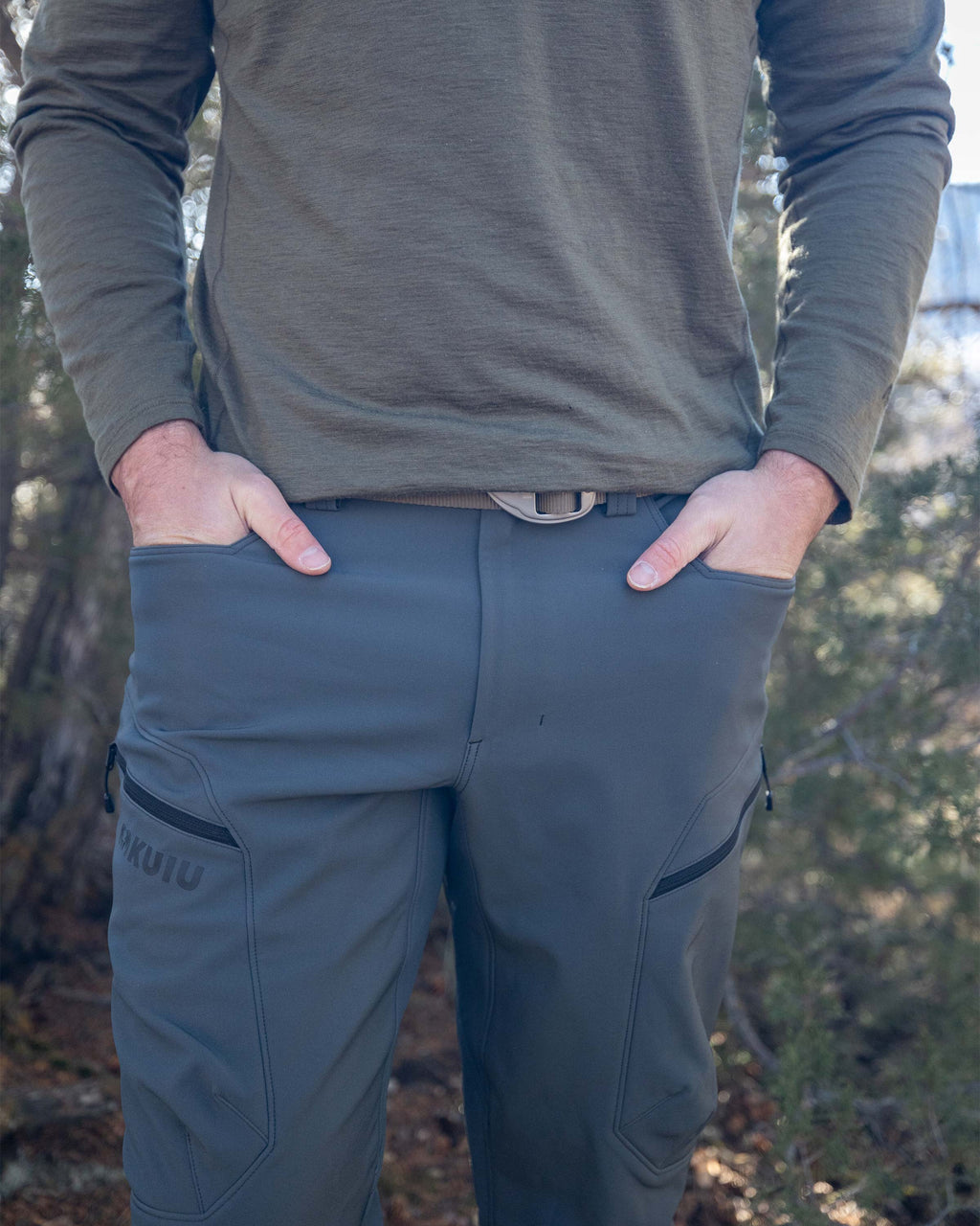 Hunter Wearing Guide PRO Pant in Gunmetal Grey with Both Hands Inside of Open Hand Pockets