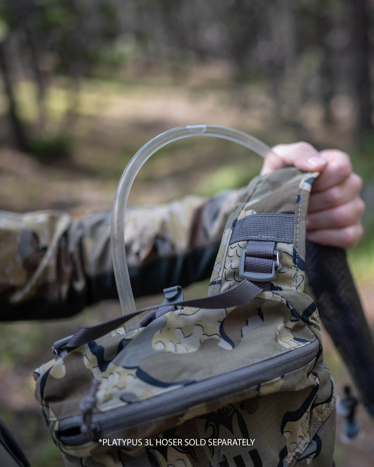 Hunter wearing Valo Camouflage and holding a Stalker PRO 500 in Valo Camouflage showcasing the hydration hose