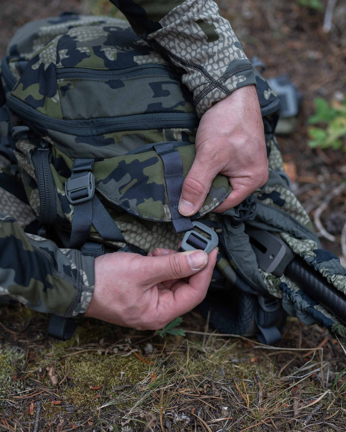 Hunter Securing Top Shroud Strap on Venture Divide 3000 in Verde Camouflage