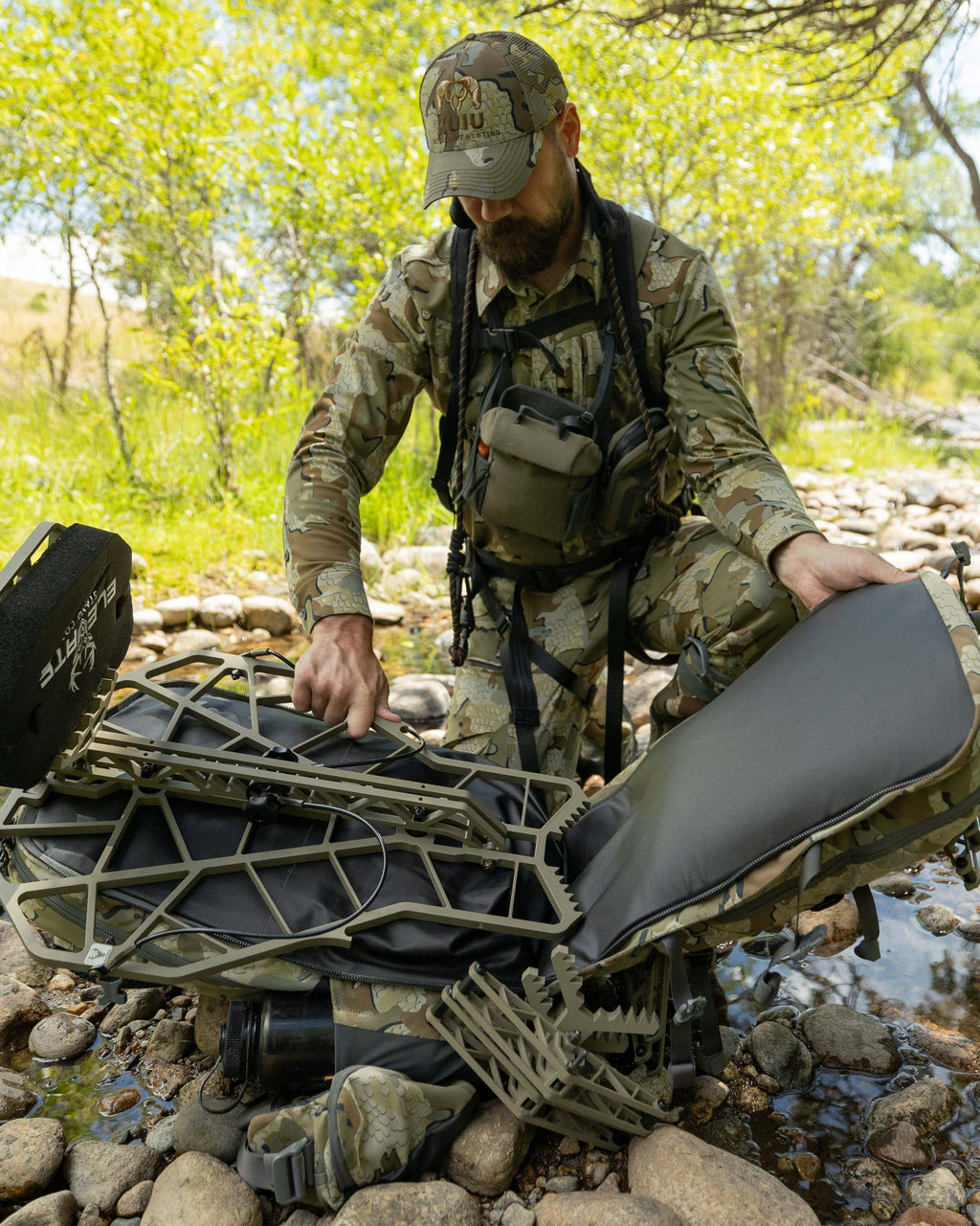 Hunter securing portable treestand in the KUIU Encounter Divide 2800 whitetail hunting day pack
