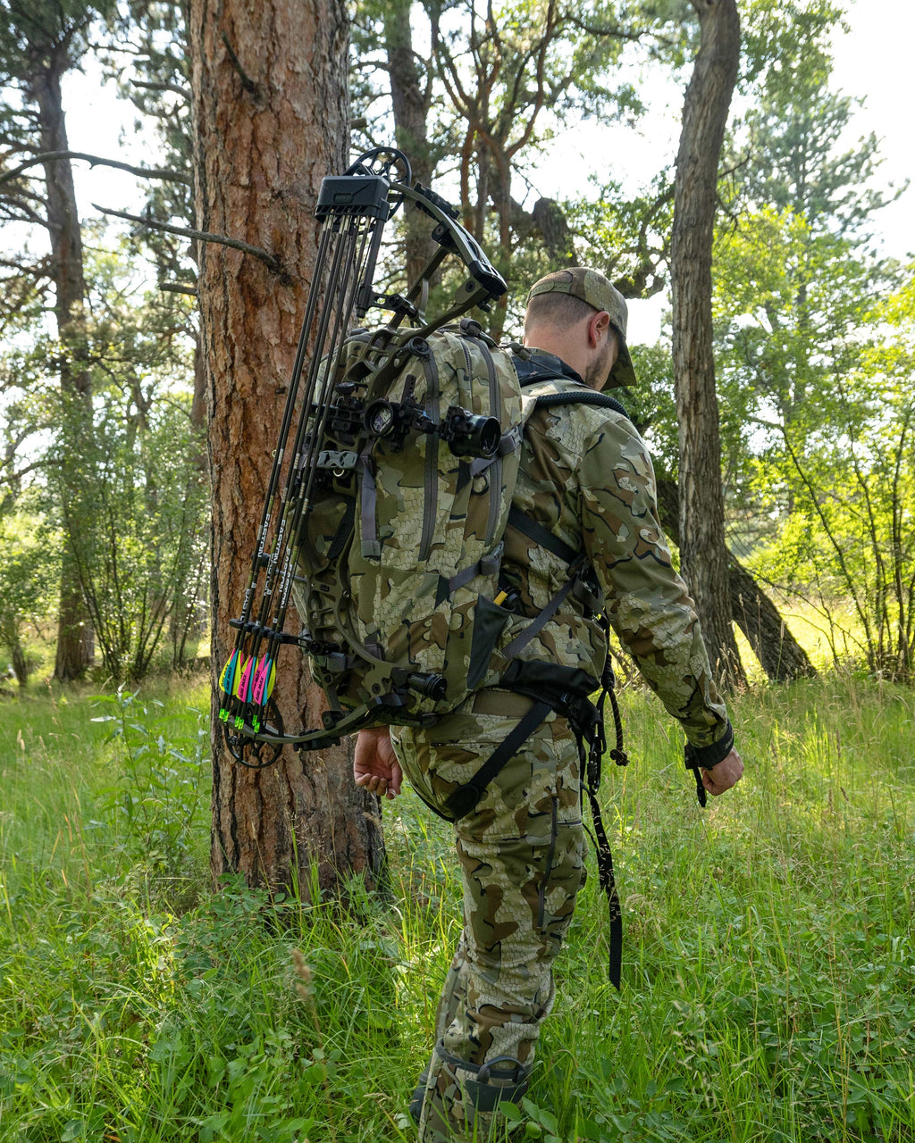 Hunter carrying his Encounter Divide 2800 in Valo Camouflage with his bow and arrow strapped to the backpack