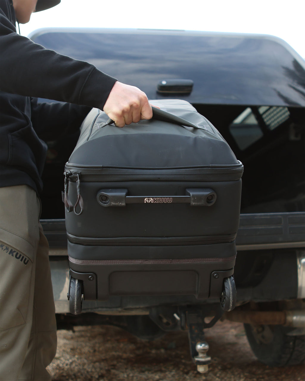 Man loading Waypoint 3000 Carry-On Roller onto the back cargo of a pickup truck