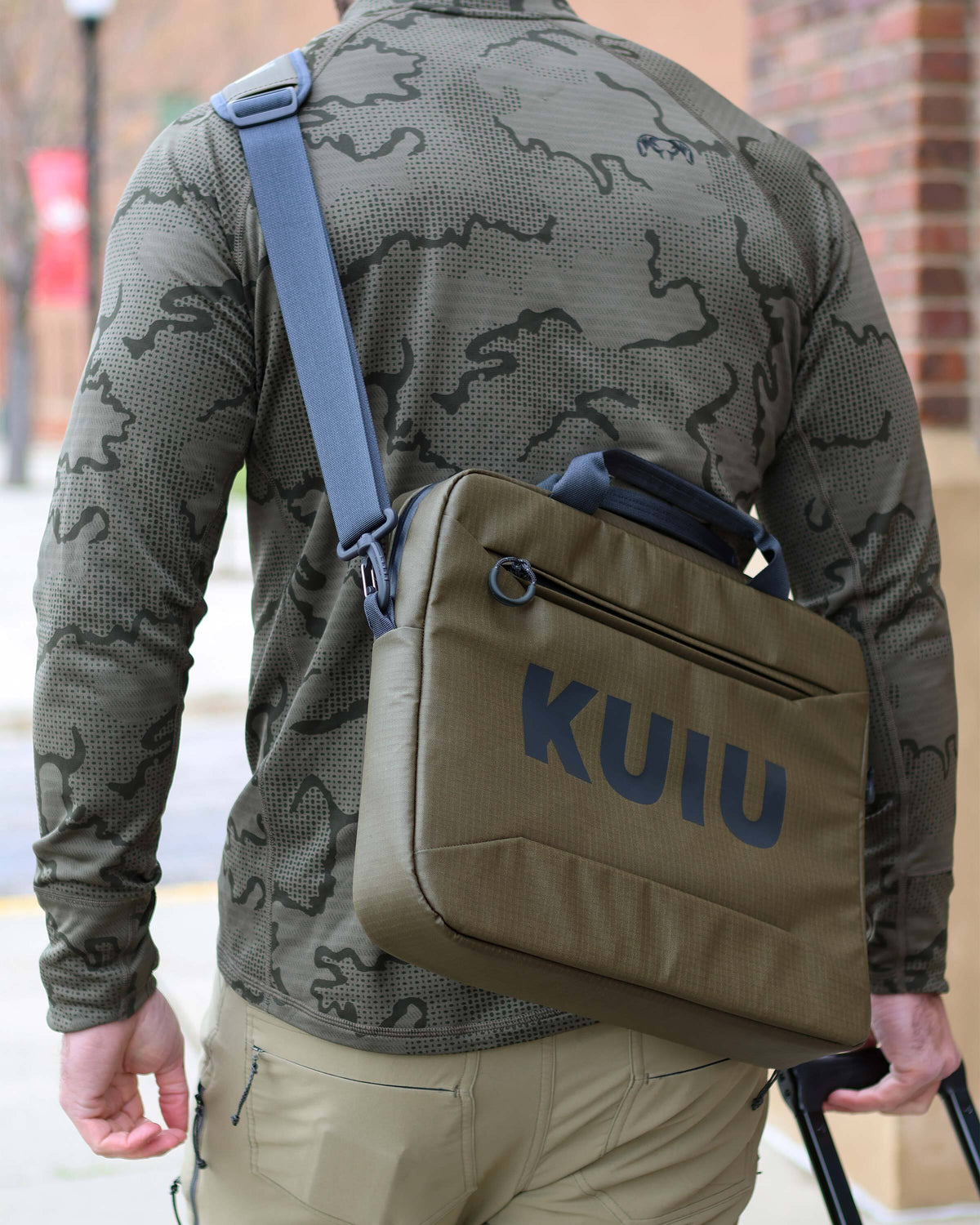 Back of man using shoulder strap as a crossbody style on the Waypoint Messenger Bag in Bourbon Brown
