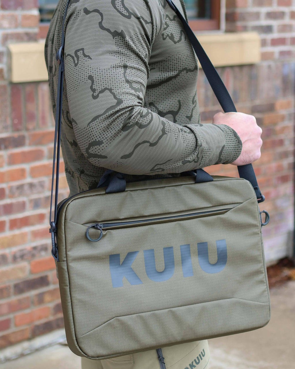 Side view of man utilizing shoulder straps to carry Waypoint Messenger Bag in Bourbon Brown