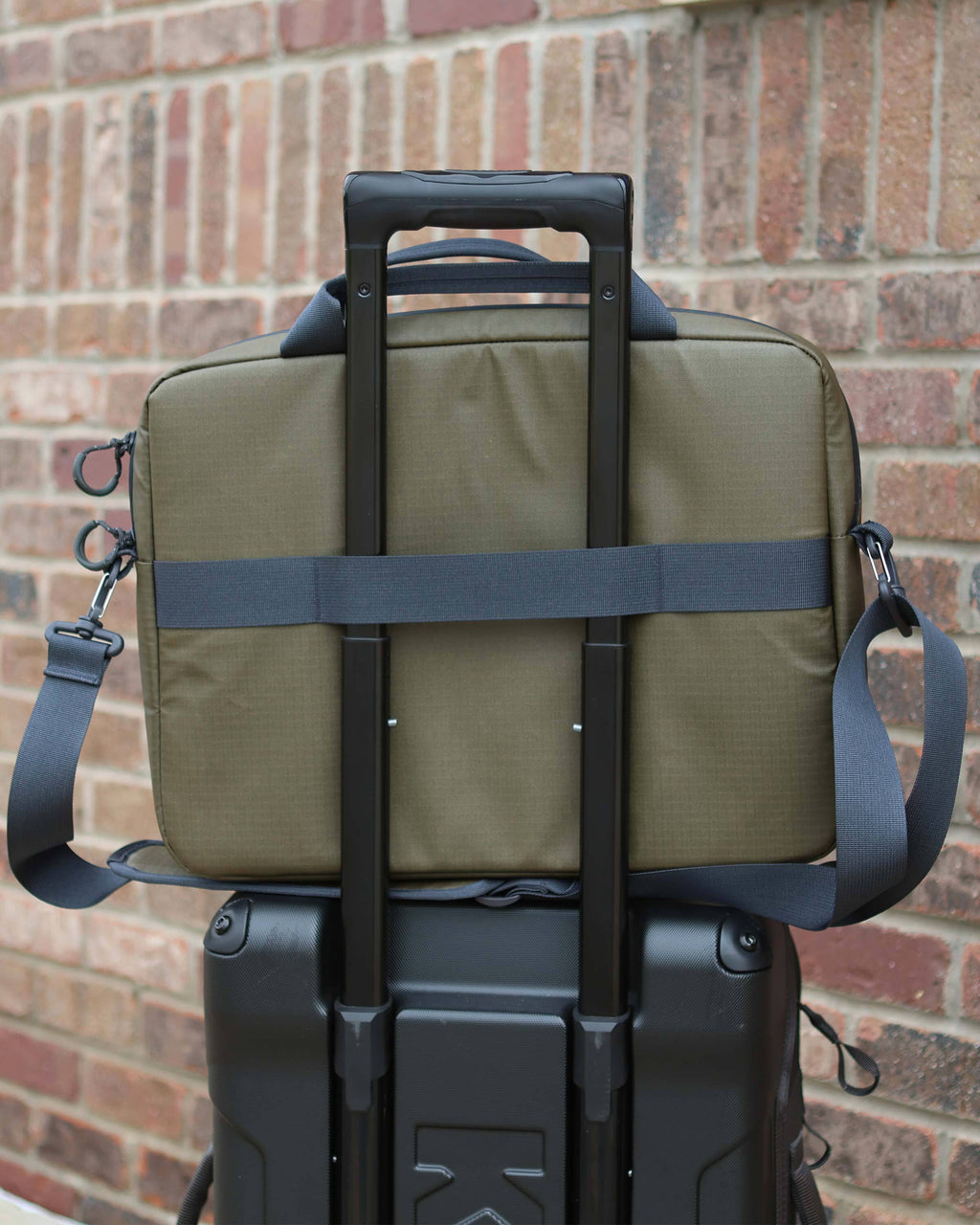 Back view of back panel on the Waypoint Messenger Bag securely placed over luggage handle