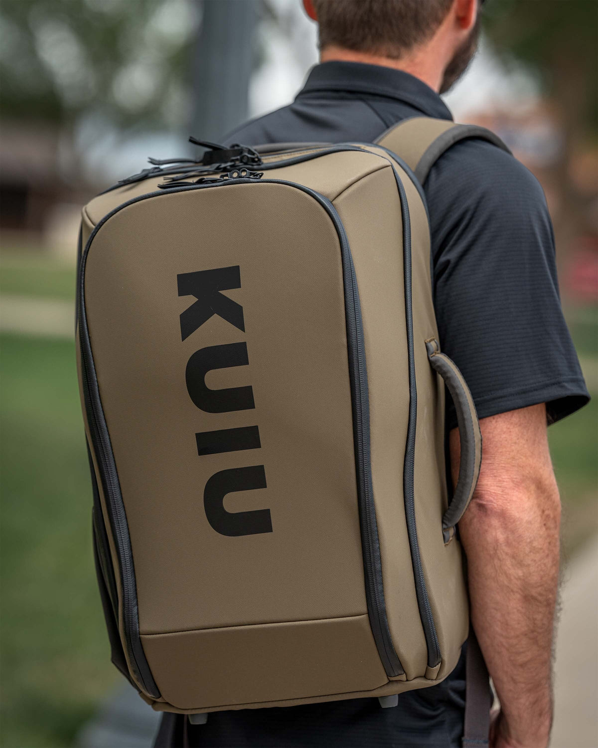 Person in an outdoor setting wearing Waypoint Travel Backpack in Bourbon Brown.