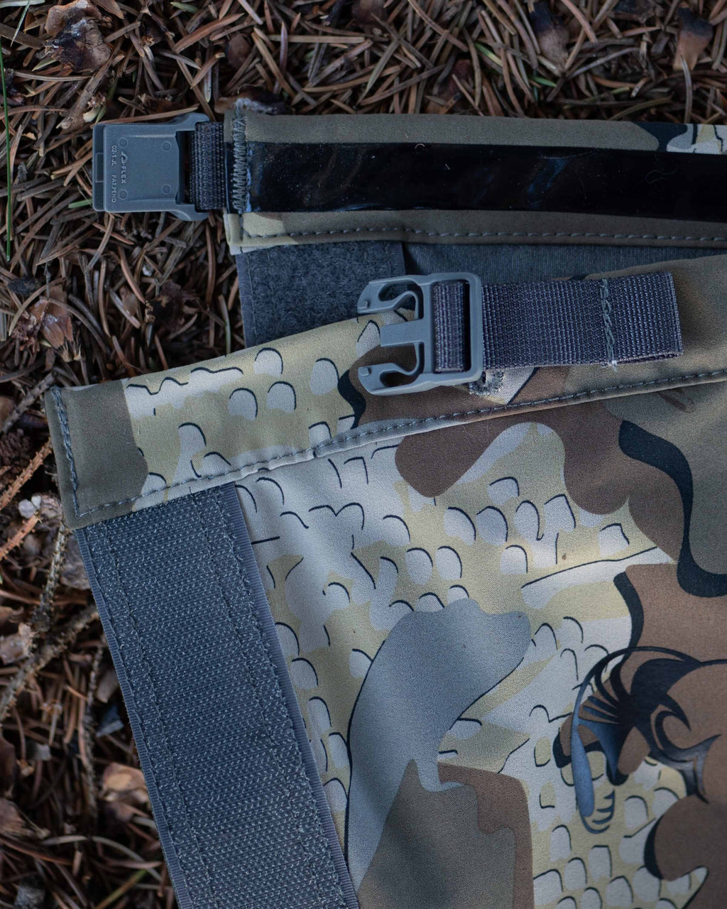Yukon HD Hunting Boot Gaiter in Valo Camouflage layed flat on pine needles showing top buckle area