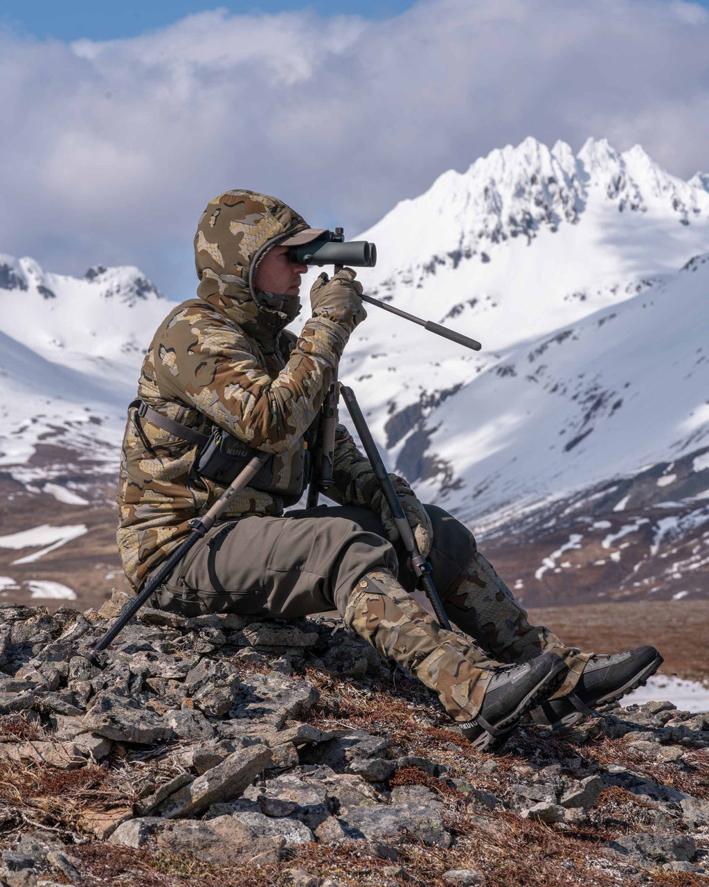 Side of Hunter Sitting on Rocks Glassing Game Wearing Kenai Packable Gloves in Valo Camouflage